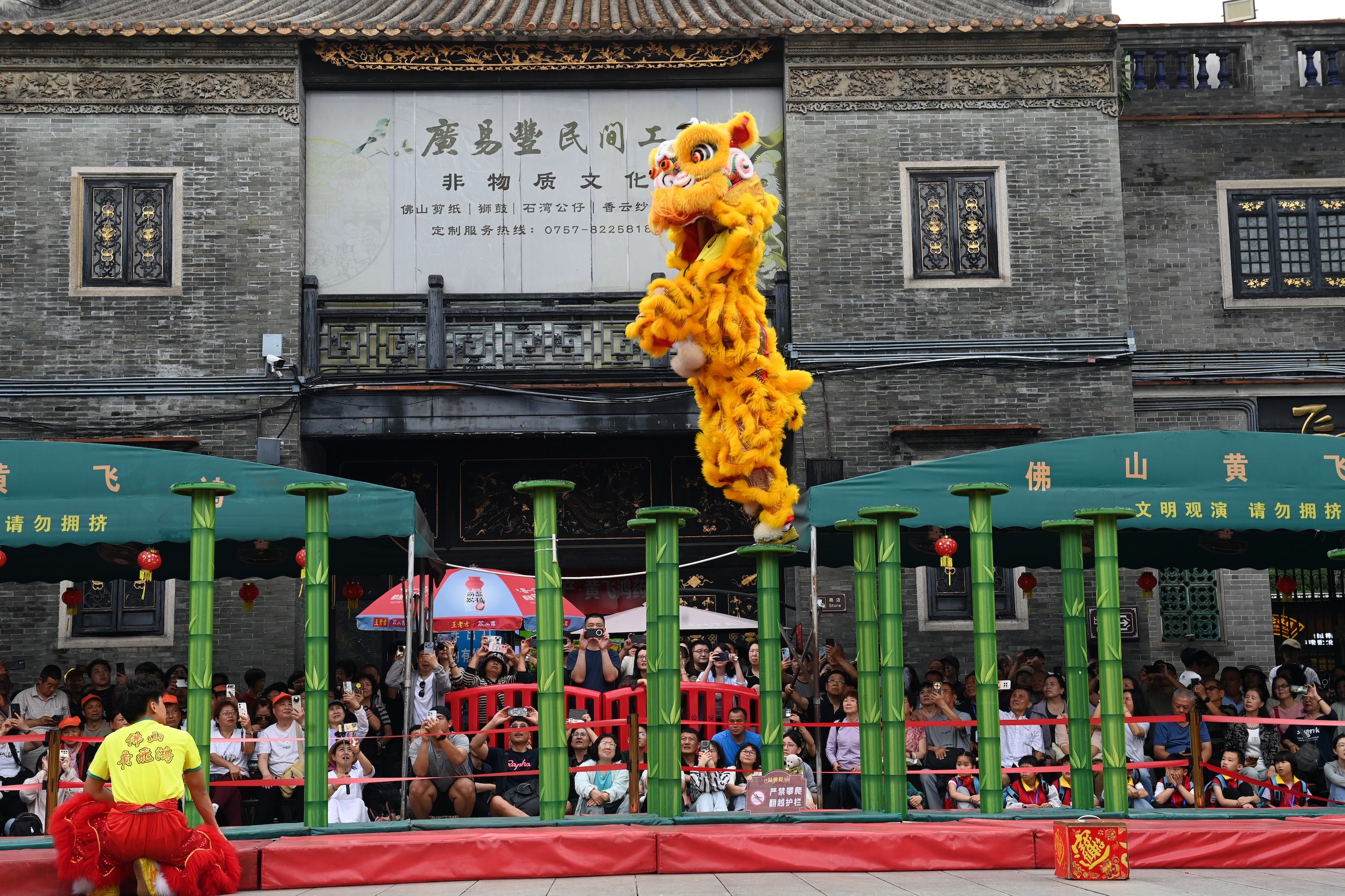 1775381247974777.jpg 佛山市祖庙博物馆醒狮表演吸引众多游客观看。陈斌摄.jpg/